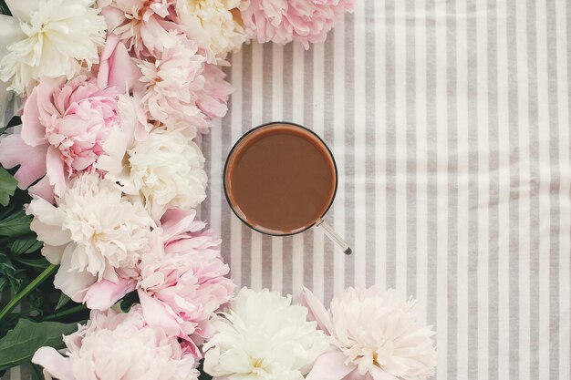 Koffiedrank in glazen beker in een prachtig roze en wit pioenrozen frame Hallo lente Goedemorgen concept Fijne moederdag