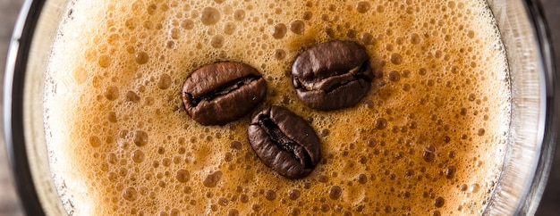 Koffieglas en koffieboon op houten lijstPanorama