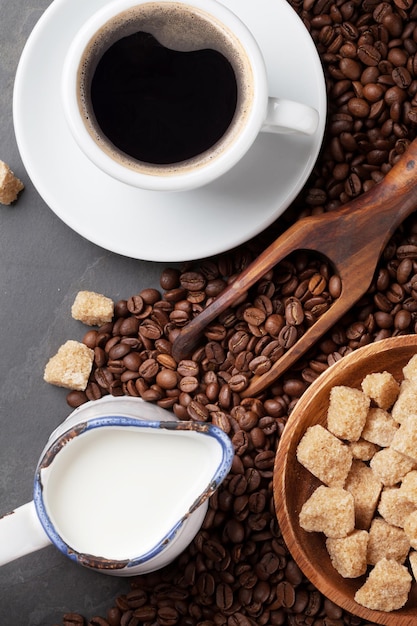 Koffiekop bonen en bruine suiker op stenen tafel