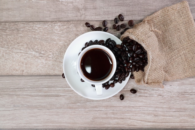 Koffiekop en koffieboon op houten bureau