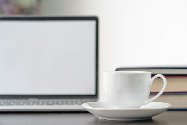 Koffiekop en laptop op tafel