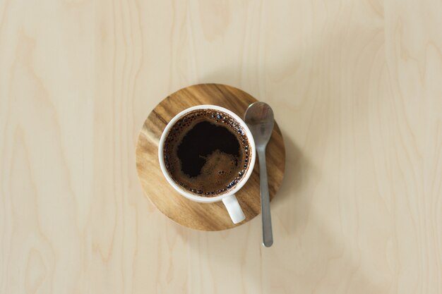 Koffiekop en schotel op een houten lijst.