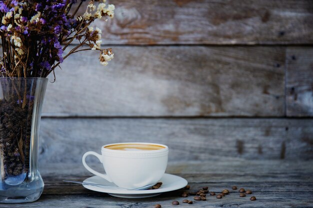 Koffiekop en vaas op hout.