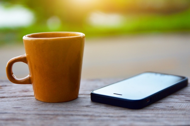 Koffiekop heet op houten lijst en groene aardachtergrond