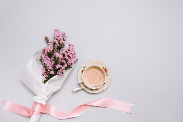 Koffiekop met bloemenboeket op lijst