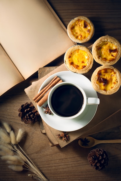 Koffiekop met oud boek op rustieke houten lijst, klassiek concept.