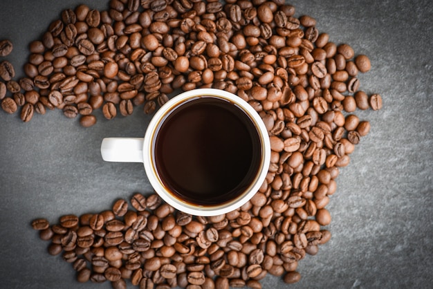 Koffiekop op geroosterde koffiebonen op de donkere hoogste mening als achtergrond