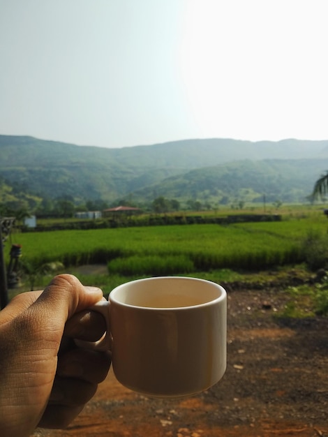 Foto koffiekop op tafel bij de bergen tegen de lucht