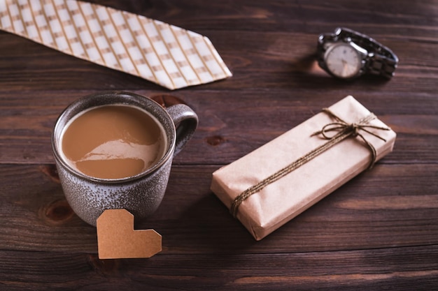 Foto koffiekop van vadersdag kartonnen hart geschenk stropdas en horloge op houten tafel