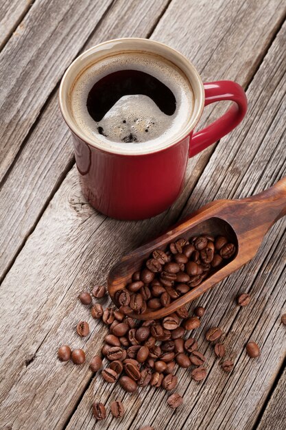 Koffiekopje en bonen op oude houten tafel