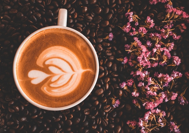 Koffiekopje en bonen op oude keukentafel