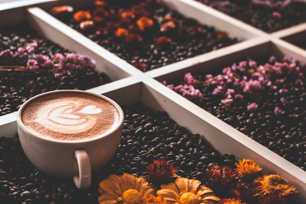 Koffiekopje en bonen op oude keukentafel