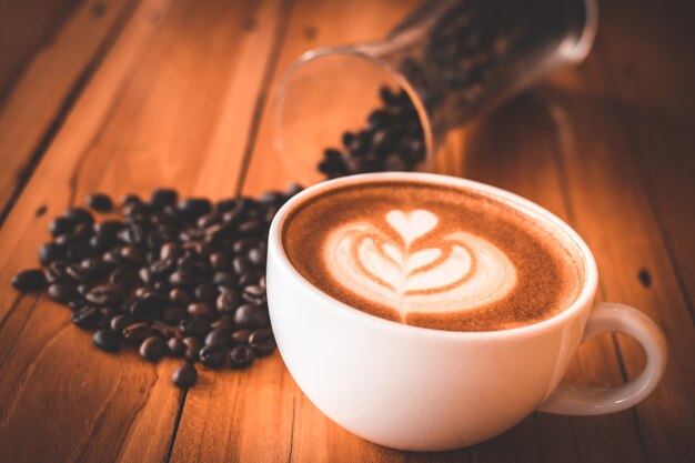 Koffiekopje en bonen op oude keukentafel