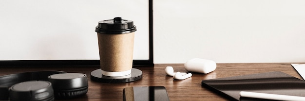 Koffiekopje en een digitale tablet op een houten bureau