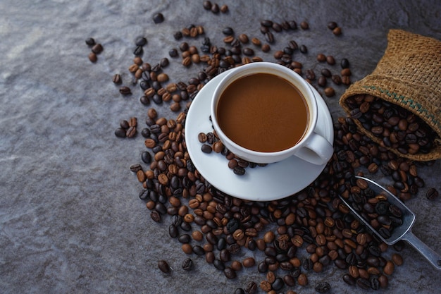 Koffiekopje en gebrande koffiebonen in bruine zak, bovenaanzicht.