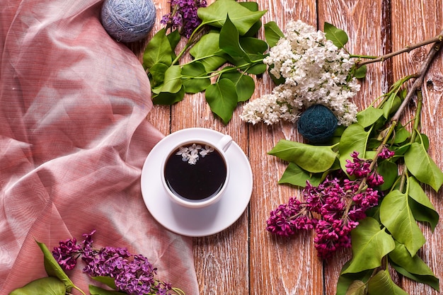 Koffiekopje en kleurrijke lila bloemen op houten tuintafel