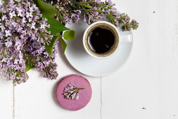 Koffiekopje en kleurrijke lila bloemen op tuintafel