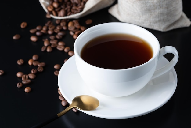 Koffiekopje en koffiebonen op de zwarte tafel