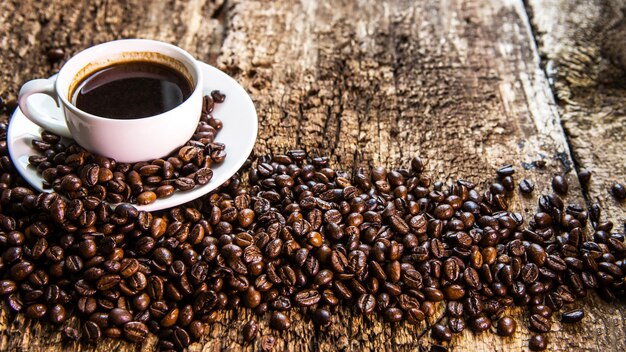 Koffiekopje en koffieboon op een houten tafel Koffie in een witte mok