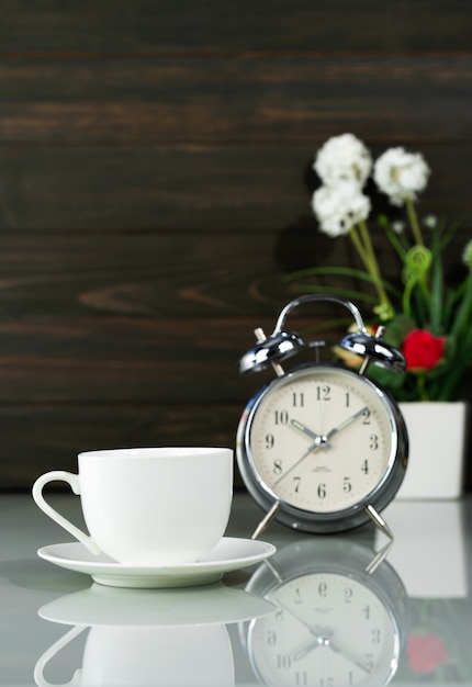 Foto koffiekopje en wekker op tafel