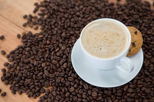 Koffiekopje met koekje en koffiebonen