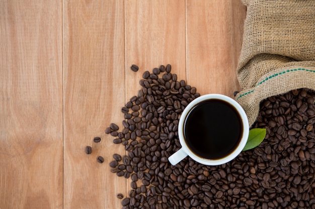 Koffiekopje met koffiebonen en koffieblad