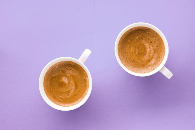 Koffiekopje op paarse achtergrond bovenaanzicht flatlay