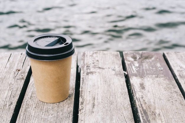 Koffiekopje op zee en bruin hout