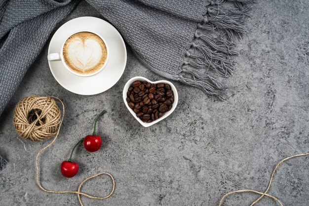 Koffiekopje, sjaal, kersen en koffiebonen