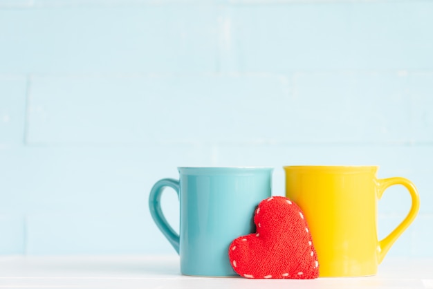 Koffiekoppen op houten lijst met met de hand gemaakt rood hart. Vriendschap dag concept