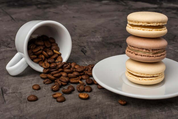 Koffiekorrels gemorst uit een witte kop tegen een donkere achtergrond