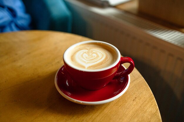 Koffieliefhebber top view van hete koffiekop met een barista kunst hartvormige schuim op houten tafel