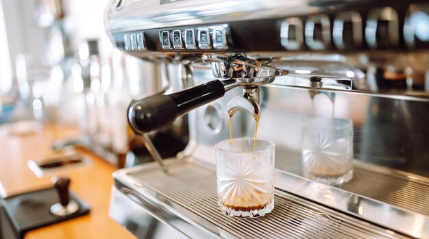 Koffiemachine die verse koffie bereidt en in rode kopjes giet in een restaurant, bar of pub