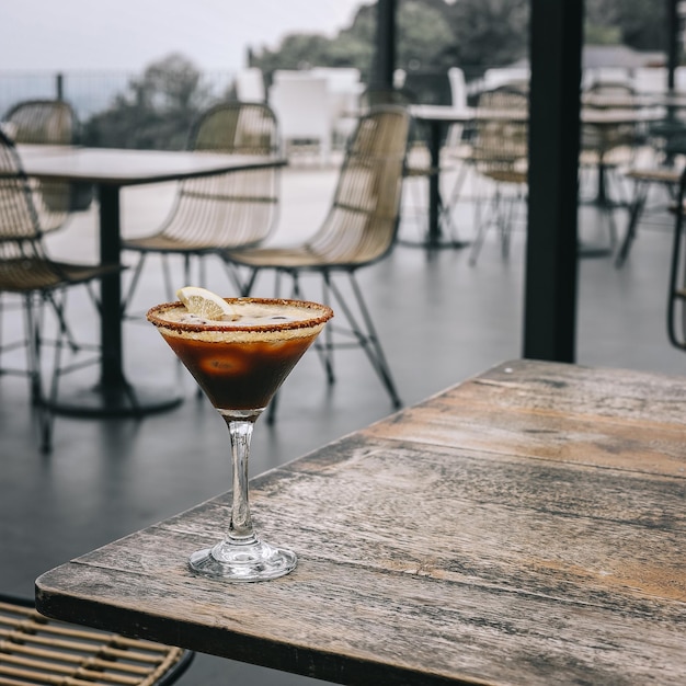 Koffiemocktail met sunkist-garnituur op een houten tafel in een openluchtbar