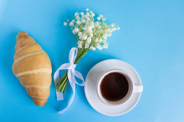 Koffiemok boeket lelietje-van-dalen bloemen mooi ontbijt bovenaanzicht croissant en koffie