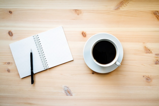 Koffiemok en een blanco kladblok met pen