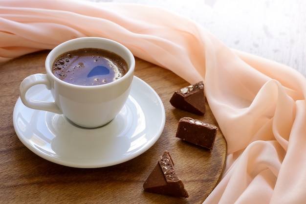 Foto koffiemok op houten tafel en beige doek