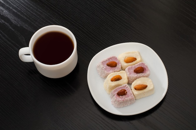 Koffiemok, schotel met Turks fruit op een zwarte tafel, bovenaanzicht