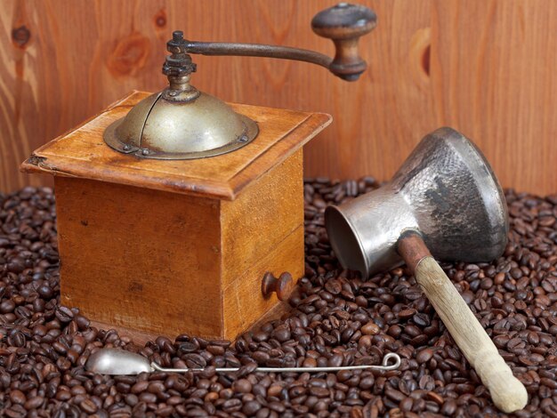 Foto koffiemolen en koperen pot op geroosterde bonen