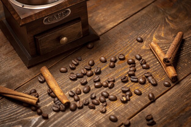 Koffiemolen met bonen kaneel op houten tafel