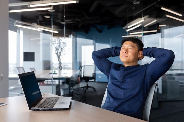 Koffiepauze jonge man Aziatische zakenman freelancer zittend aan het bureau op kantoor op een stoel hij