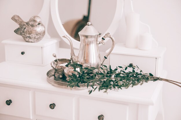 Koffieservies en olijftak op tafel in het boudoir