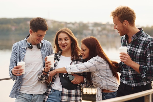 Koffietijd Groep jonge vrolijke vrienden die buiten samen plezier hebben