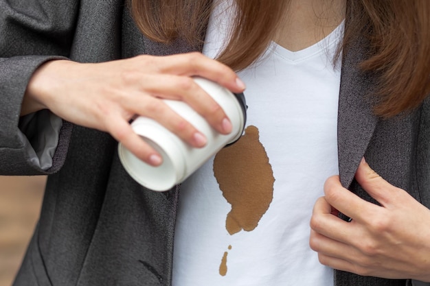 Koffievlek Onherkenbaar meisje dat hete koffie op zichzelf morst