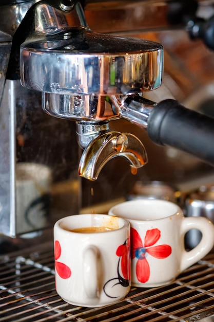 Koffiezetapparaat Espresso-koffie maken in kopje op houten bar