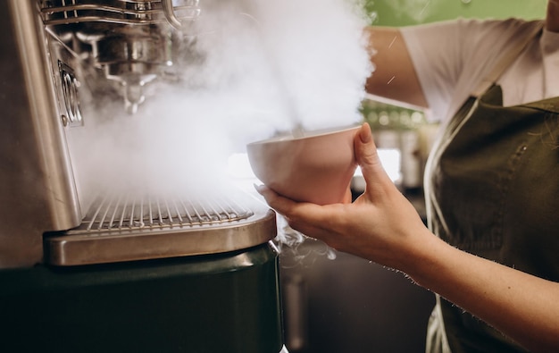 Koffiezetapparaat in stoombarista die koffie bereidt in café