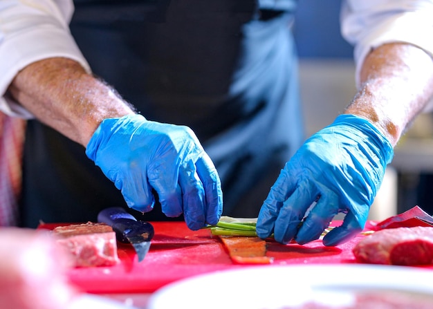 Kok bereidt een maaltijd voor in de keuken Kok kookt Kok versiert een gerecht