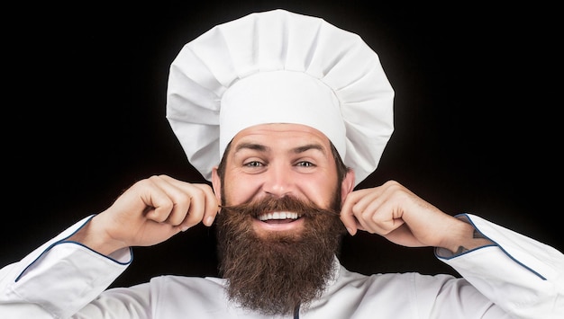 Kok hoed. Bebaarde chef-kok, kok of bakker. Bebaarde mannelijke chef-koks geïsoleerd op zwart. Grappige chef-kok met baardkok. Baardmens en snor die slabschort dragen. Luie man. Portret van een gelukkige chef-kok