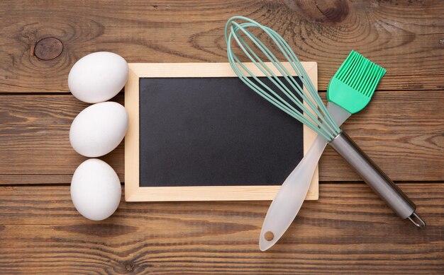 Foto koken achtergrond keukengerei eieren leeg krijtbord op houten tafel