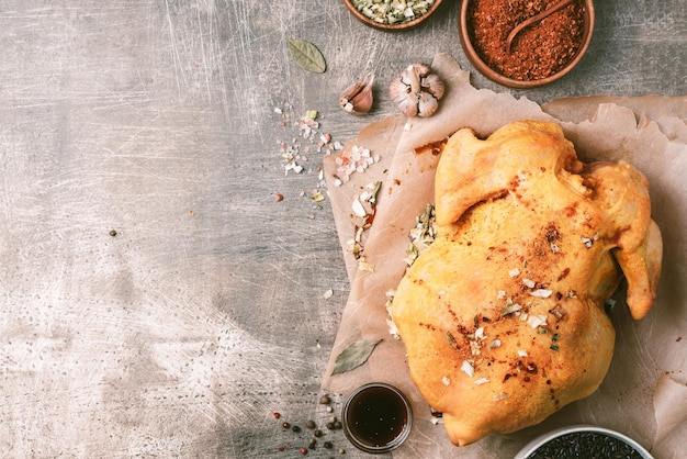 Koken bereiding van rauwe kip met ingrediënten specerijen kruiden saus en kooklepel op grijze betonnen achtergrond Bovenaanzicht Kopieer ruimte Koken ingrediënten frame